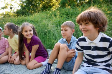 Çocuklar yaz günü doğada vakit geçirirler.