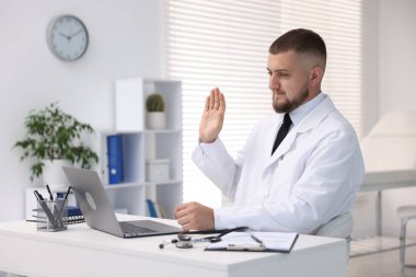 Klinikte bilgisayarla online danışmanlık yapan bir doktor