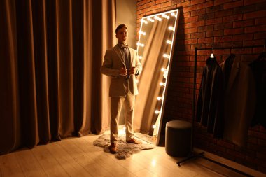 Yakışıklı adam aynanın yanında hazırlanıyor.