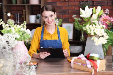Dükkandaki ahşap masada çalışan profesyonel bir çiçekçi.