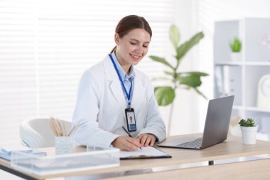 Teletıp. Doktor içeride bilgisayarla hastayla görüntülü konuşma yaparken not alıyor.