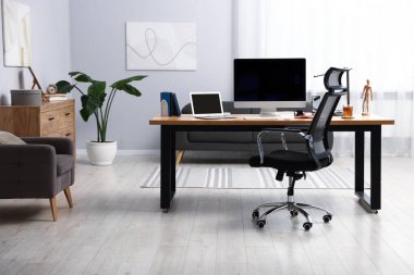 Modern bilgisayarlı, ahşap masa içinde şık bir iş yeri.