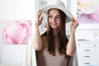 Hazırlanıyor. Evde şık giyinmiş genç bir kadın var.