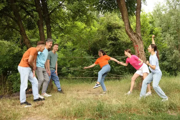 Takım oluşturma. Bir grup mutlu insan dışarıda örümcek ağı oynuyor.