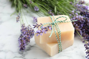 Sabun çubukları ve lavanta çiçekleri beyaz mermer masada, yakın plan.