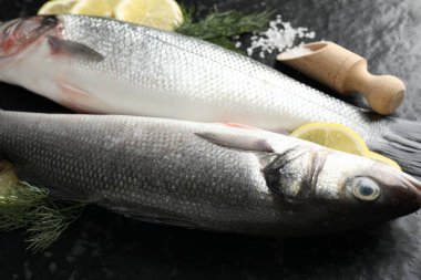Siyah masada baharatlı taze çiğ deniz kabuğu, yakın plan. Balık ve deniz ürünleri lezzetleri