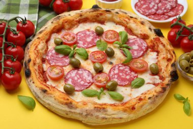 Salamlı, zeytinli, domatesli ve fesleğenli lezzetli pizza.