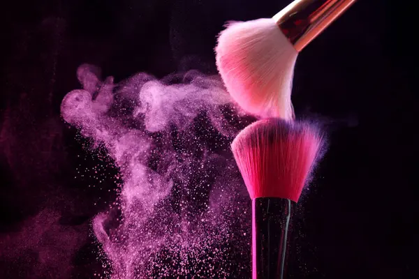 Siyah arka planda pembe göz farlı makyaj fırçaları, yakın plan. Metin için boşluk