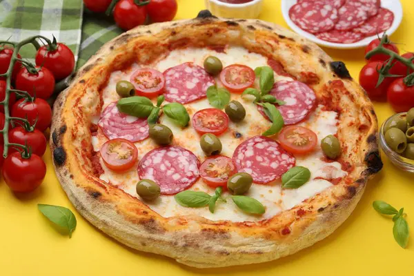 Salamlı, zeytinli, domatesli ve fesleğenli lezzetli pizza.