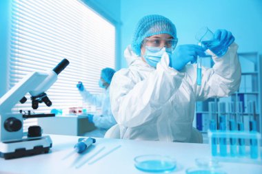 Tıbbi analiz. Laboratuvarda numuneyle çalışan bilim adamı, seçici odaklanma