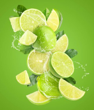 Yeşil arka planda taze limon ve su sıçratan bir içecek.