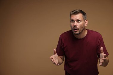 Kahverengi arka planda panik atak geçiren adam, mesaj için boşluk