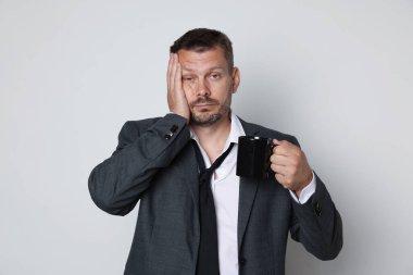 Beyaz arka planda içki mahmurluğu çeken bir adam.