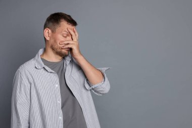 Gri arka planda akşamdan kalma bir adam, metin için boşluk.