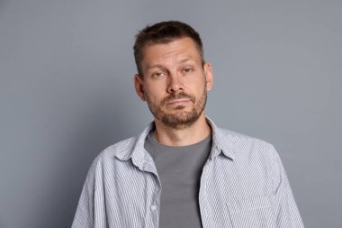 Gri arka planda akşamdan kalma bir adam.