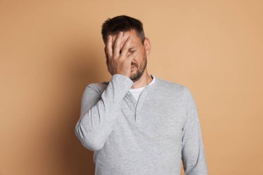 Bej arka planda akşamdan kalma bir adam.