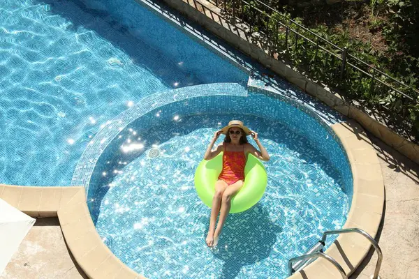 Yüzme havuzunda şişme yüzük takan güzel bir kız.