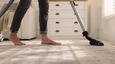 Halıyı elektrikli süpürgeyle temizleyen kadın, yakın çekim.