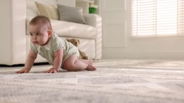 Evde yerde sürünen sevimli küçük bebek, sola hareket eden kamera.