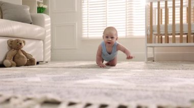 Evde yerde sürünen sevimli küçük bebek, kamera hareket ediyor.