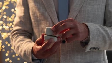 Evlenme teklif ediyorum. Nişan yüzüğünün olduğu kutuyu açan adam içeride, kamera içeri giriyor. Bokeh etkisi