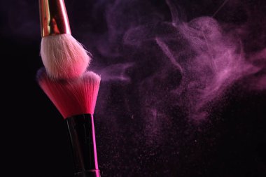 Renkli göz gölgeli makyaj fırçaları siyah arka planda neon ışıkları, yakın plan. Metin için boşluk