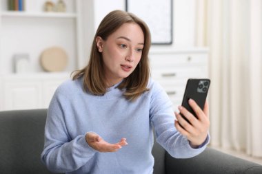 Kadın akıllı telefondan doktorla çevrimiçi olarak görüşüyor.