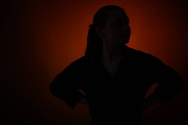 Karanlık arkaplanda poz veren kadın silueti