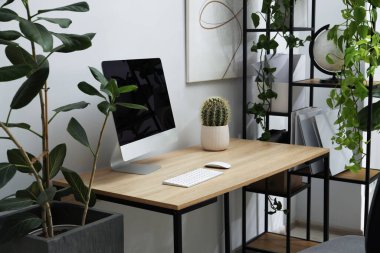 Biyofilik iç tasarım. Ofisinde bilgisayar ve ev bitkileri olan şık bir iş yeri