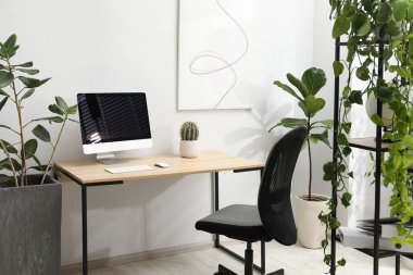 Biyofilik iç tasarım. Ofisinde bilgisayar ve ev bitkileri olan şık bir iş yeri