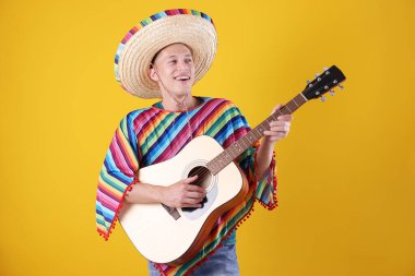 Şapkalı mutlu adam ve sarı arka planda gitar çalan renkli panço.