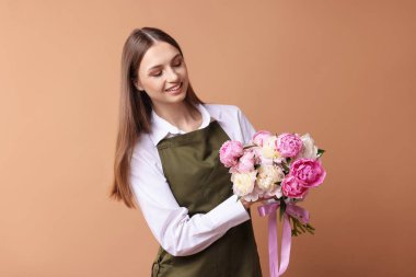 Koyu bej arka planda güzel şakayık demeti olan bir çiçekçi.