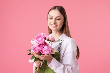 Pembe arka planda güzel şakayıklar olan bir çiçekçi.