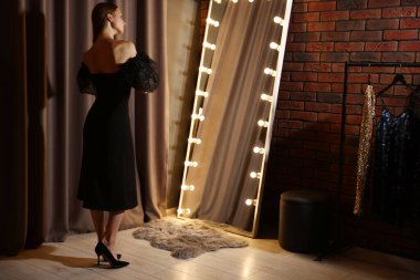 Güzel bir kadın aynanın yanında hazırlanıyor.