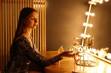 Güzel bir kadın tuvalet masasında hazırlanıyor.