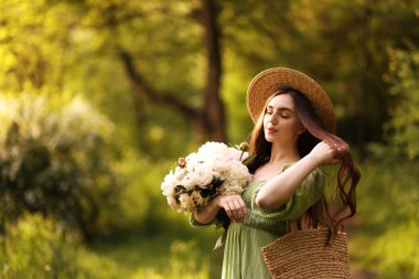 Parkta şakayık demeti olan güzel bir kadın. Metin için boşluk