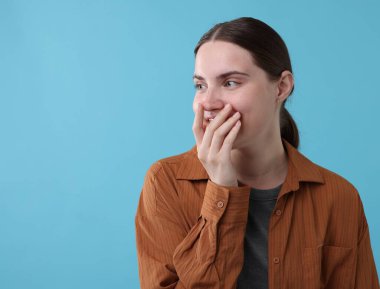 Açık mavi arka planda gülen güzel bir kadın. Metin için boşluk