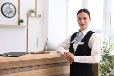 Oteldeki işyerinde gülümseyen resepsiyonistin portresi
