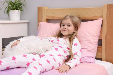 Evde yatağında yastığı olan tatlı küçük kız.