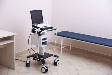 Modern ultrason makinesi ve klinikte muayene yatağı