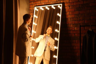 Yakışıklı adam aynanın yanında hazırlanıyor.