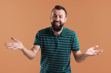 Kahverengi arka planda gülen yakışıklı bir adam. Pozitif duygu