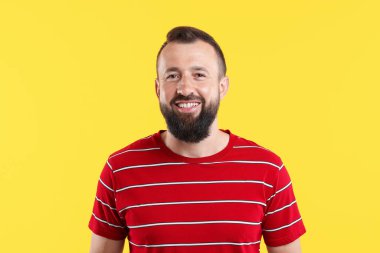 Sarı arka planda gülen yakışıklı bir adam. Pozitif duygu