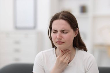 Evde boğazı ağrıyan genç bir kadın var.