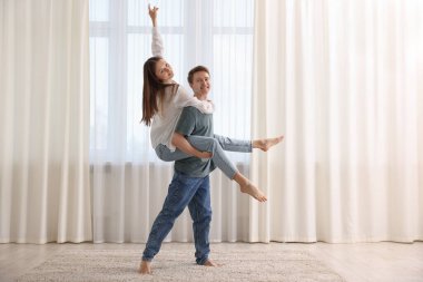Mutlu genç çift evde dans ediyor.