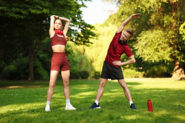 Mutlu çift parkta sabah egzersizi yapıyor.