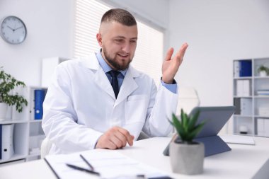 Doktor içeride tabletle çevrimiçi danışmanlık yapıyor.