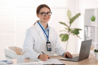 Teletıp. Doktor içeride bilgisayarla hastayla görüntülü konuşma yaparken not alıyor.