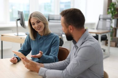 Ofiste tabletle çalışan gülümseyen iş ortakları
