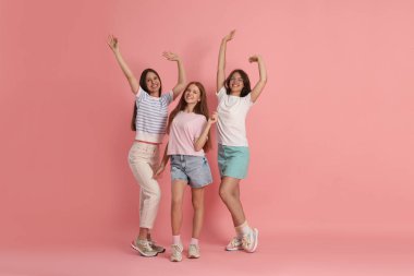 Pembe arka planda mutlu arkadaşların portresi